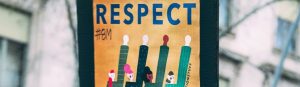 Protest poster of 4 people raising their arms in the air. The word RESPECT is written above the painted image of the 4 people.